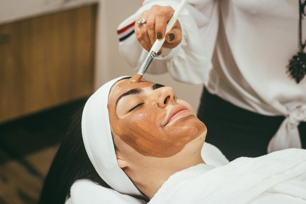 An esthetician giving a client a calm, professional facial treatment at a med spa