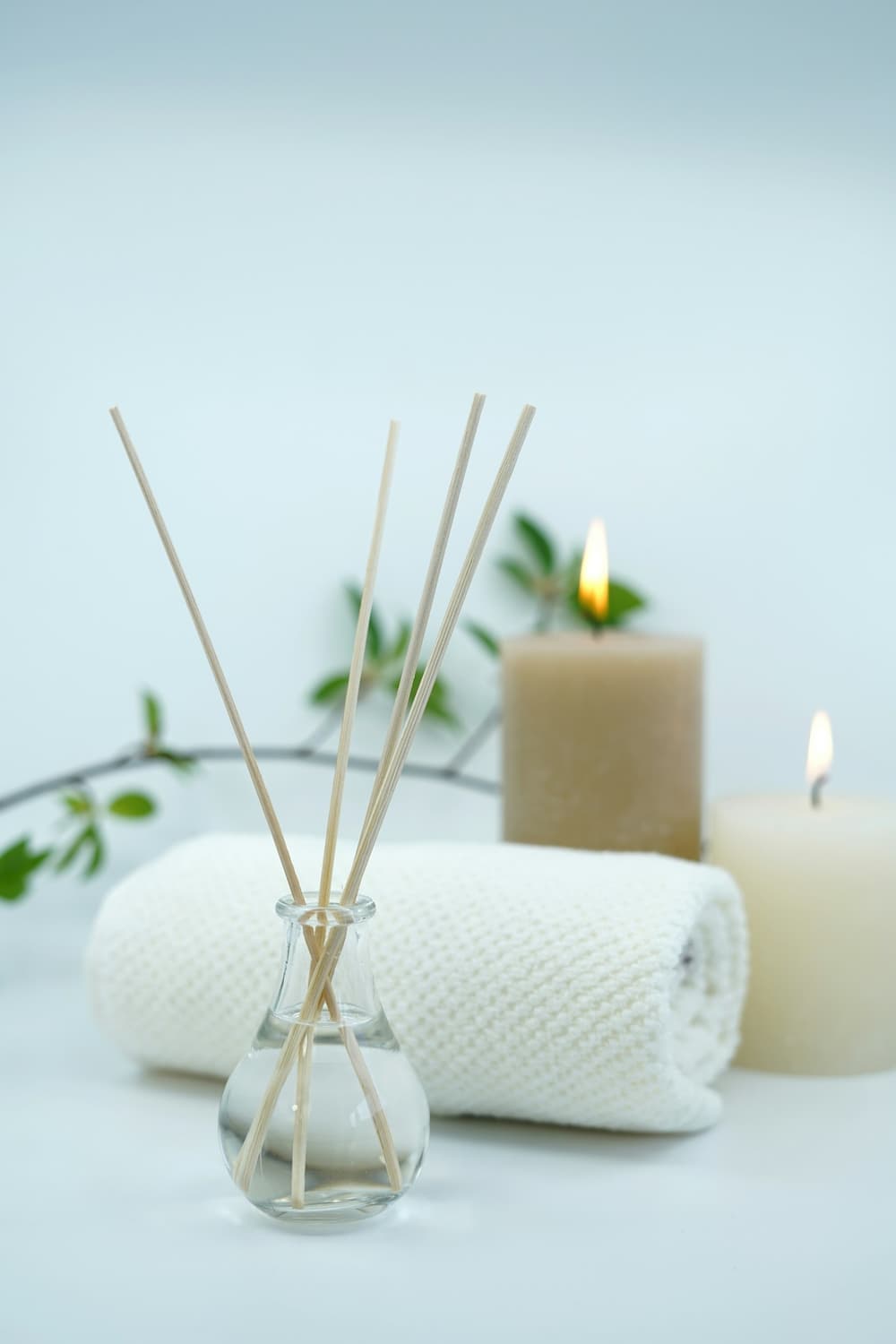 Neutral, luxe med-spa detail — rolled towel, reed diffuser and candles